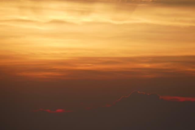 A vibrant sunset with warm orange and red hues blending into the sky, creating a serene and atmospheric scene